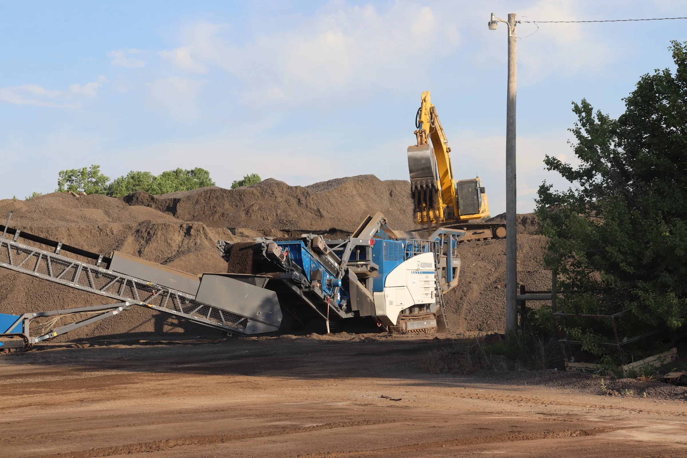 Excavator feeding the aggregate crusher at the Trinitas yard